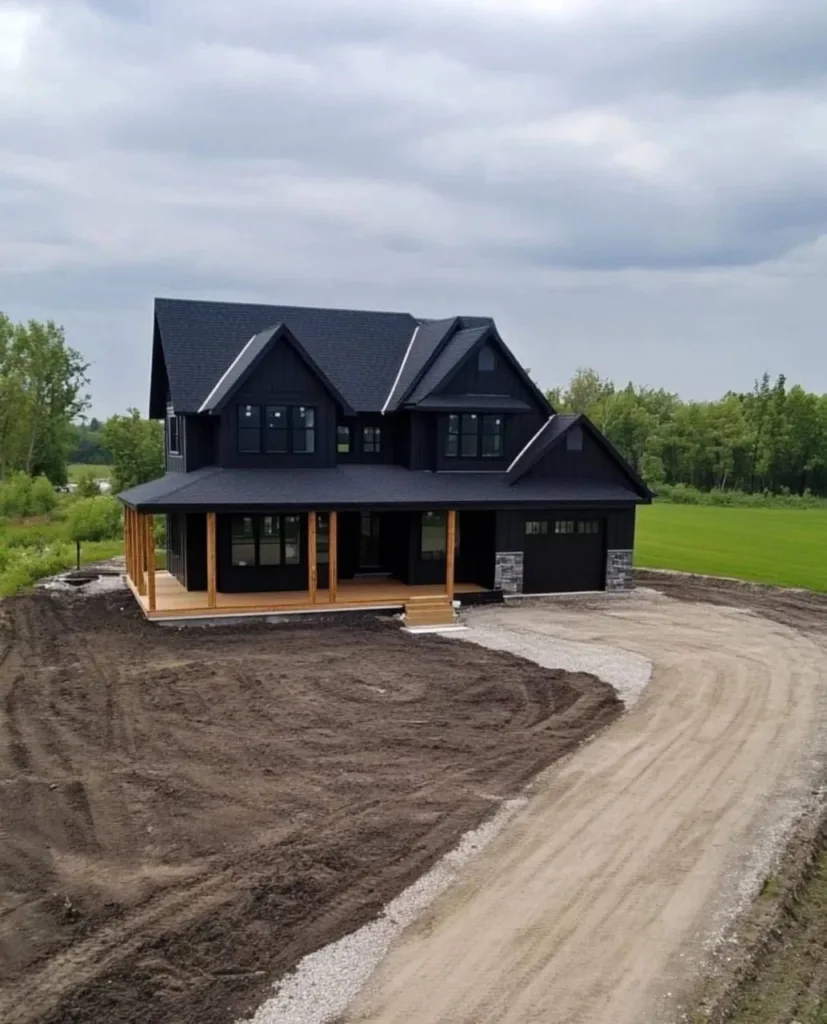 Modern black farmhouse with a gravel driveway and wood porch accents