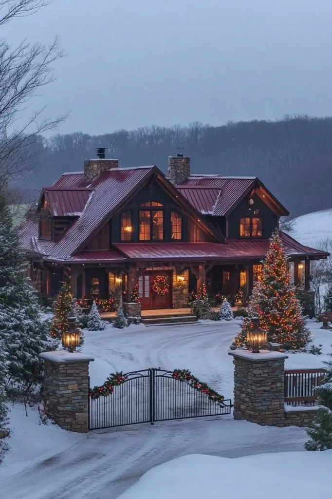 Farmhouse with a red metal roof, wood siding, and Christmas decorations, surrounded by snow.