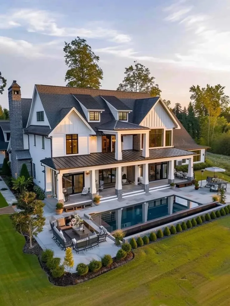 Modern farmhouse with a large wrap-around porch, a pool, and a spacious patio area.