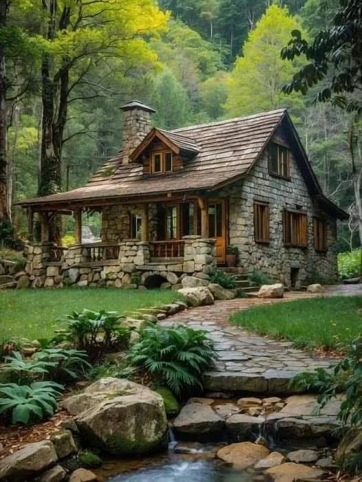 Stone cottage with large stone chimney and stream.