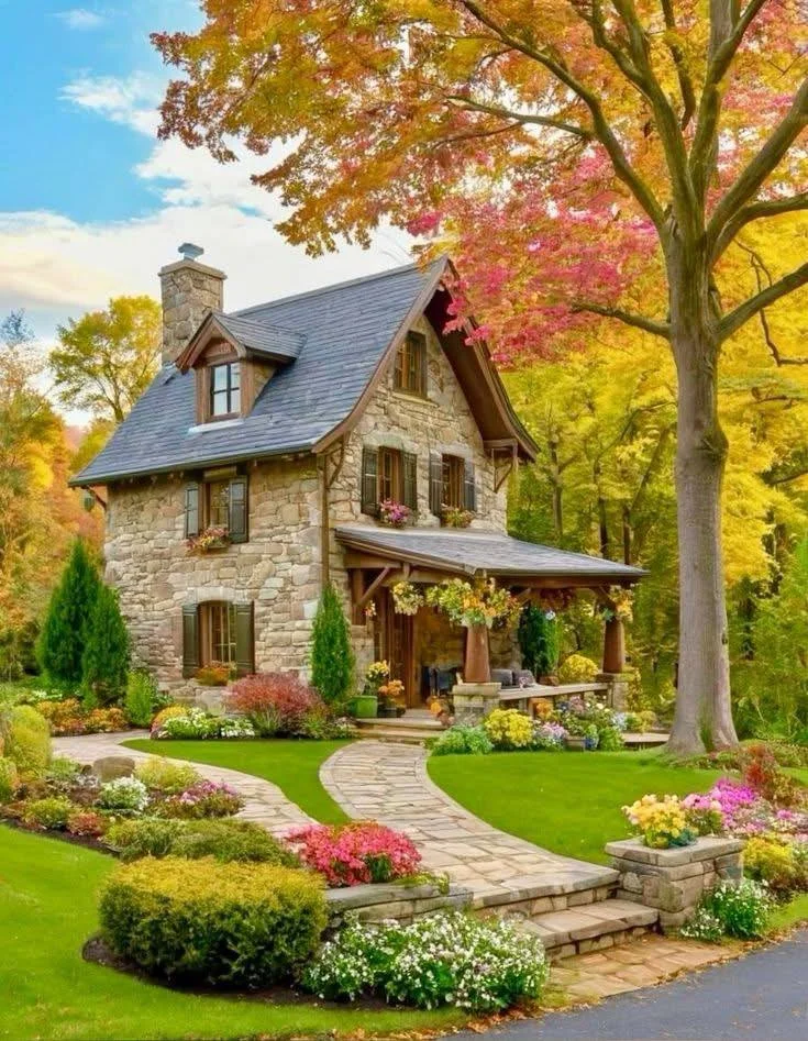 Stone cottage surrounded by autumn foliage.