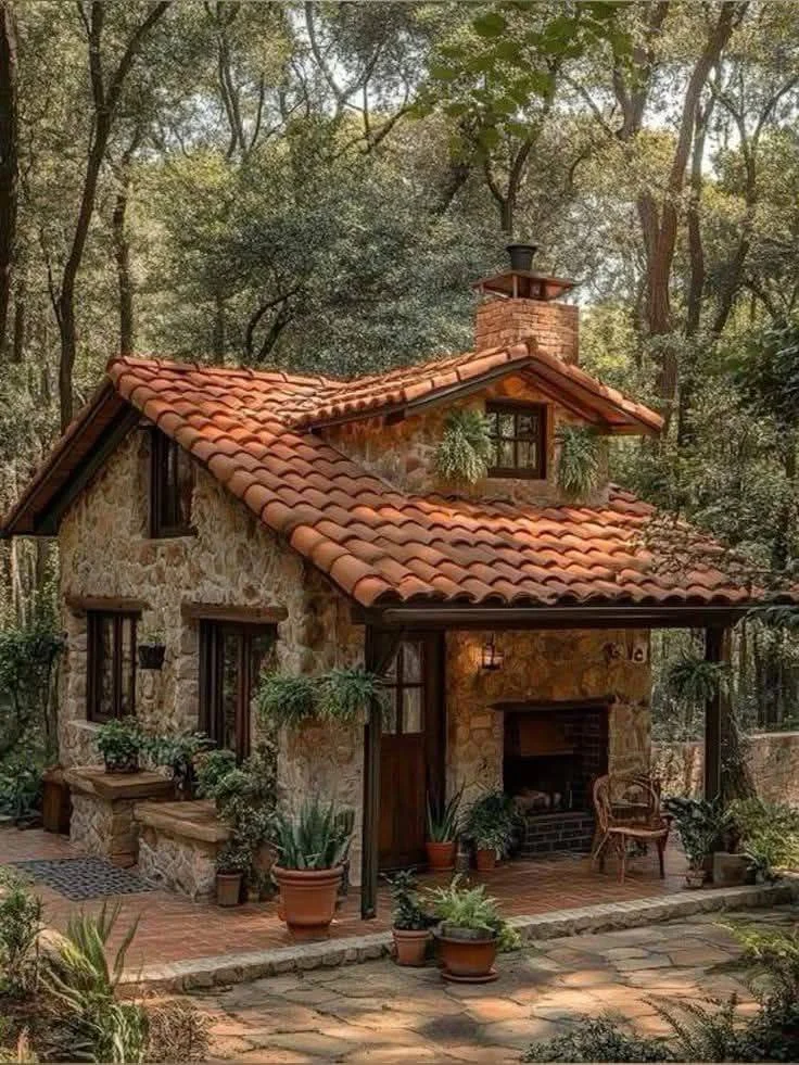 Stone cottage with covered porch and outdoor fireplace.