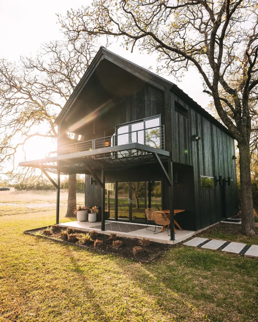 Dreamy cabin escape with dark wood exterior and large deck.