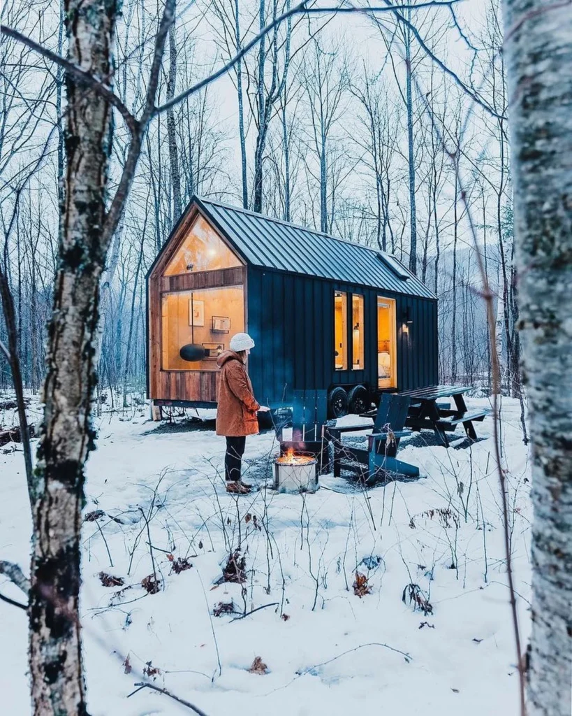 Dreamy tiny cabin in a snowy forest setting.