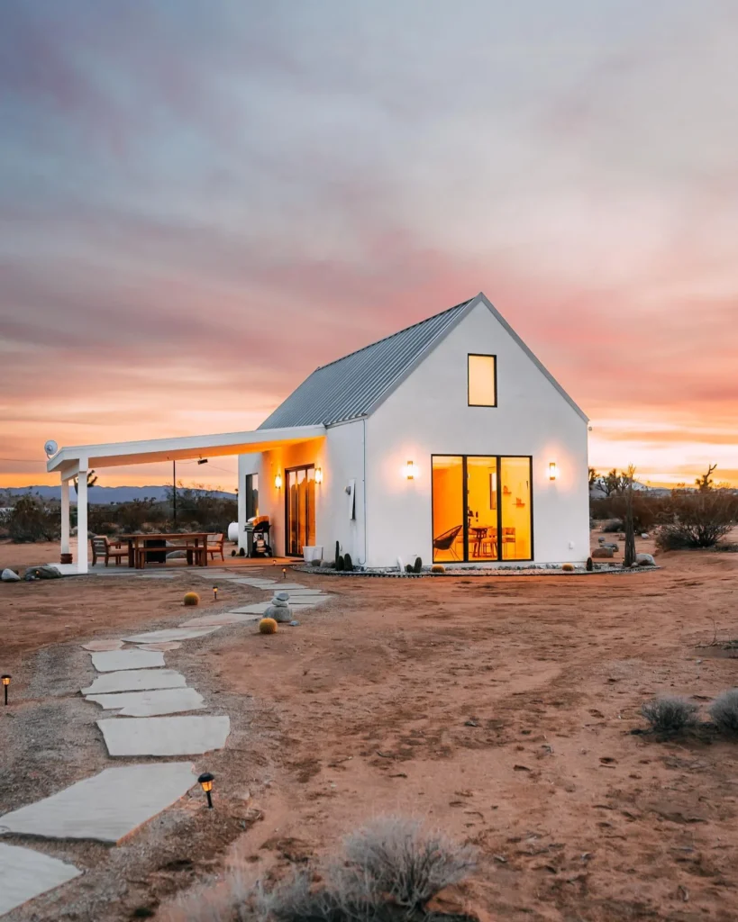 Dreamy white modern cabin in a desert landscape.