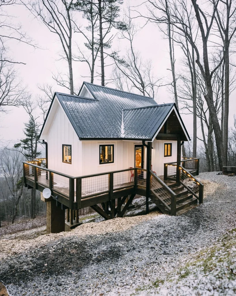 Dreamy white cabin on stilts with a wrap-around deck.