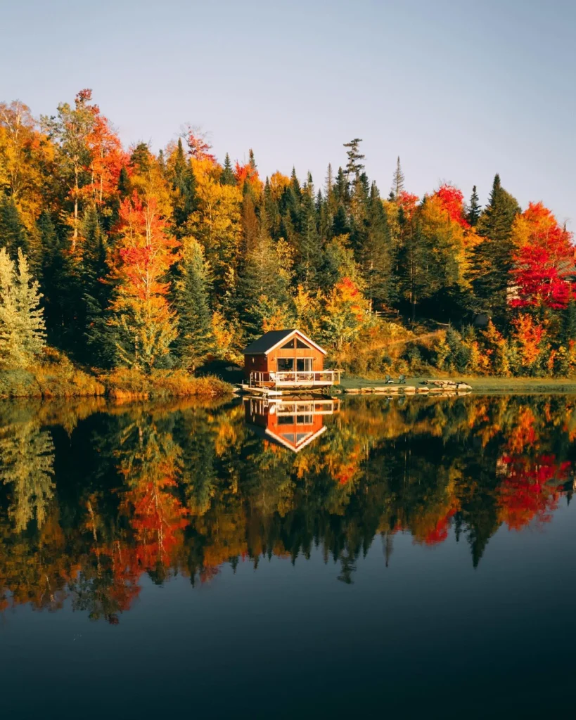 Dreamy lakeside cabin surrounded by colorful autumn trees - Dreamy Cabin Getaways