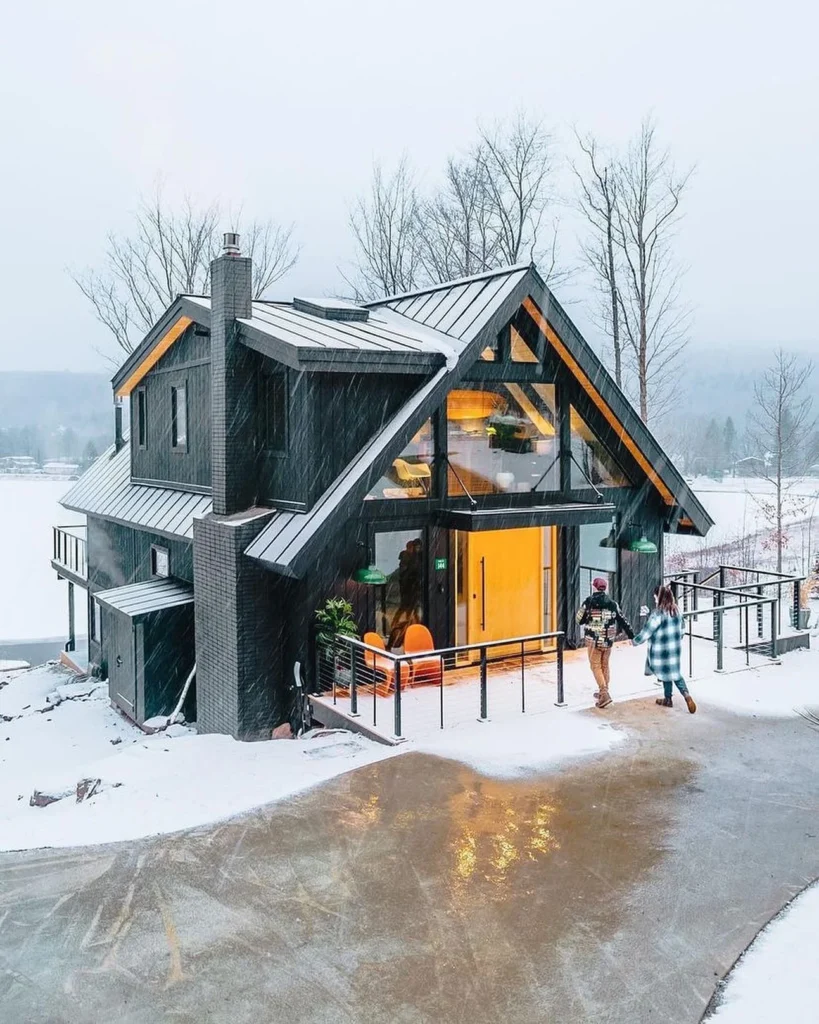 Dreamy winter cabin with angled roof and bright door.