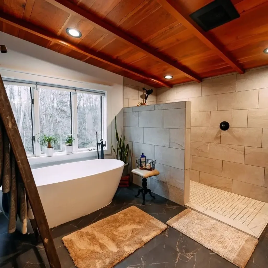 A spacious bathroom featuring a modern freestanding tub and a walk-in shower with light grey tiles.