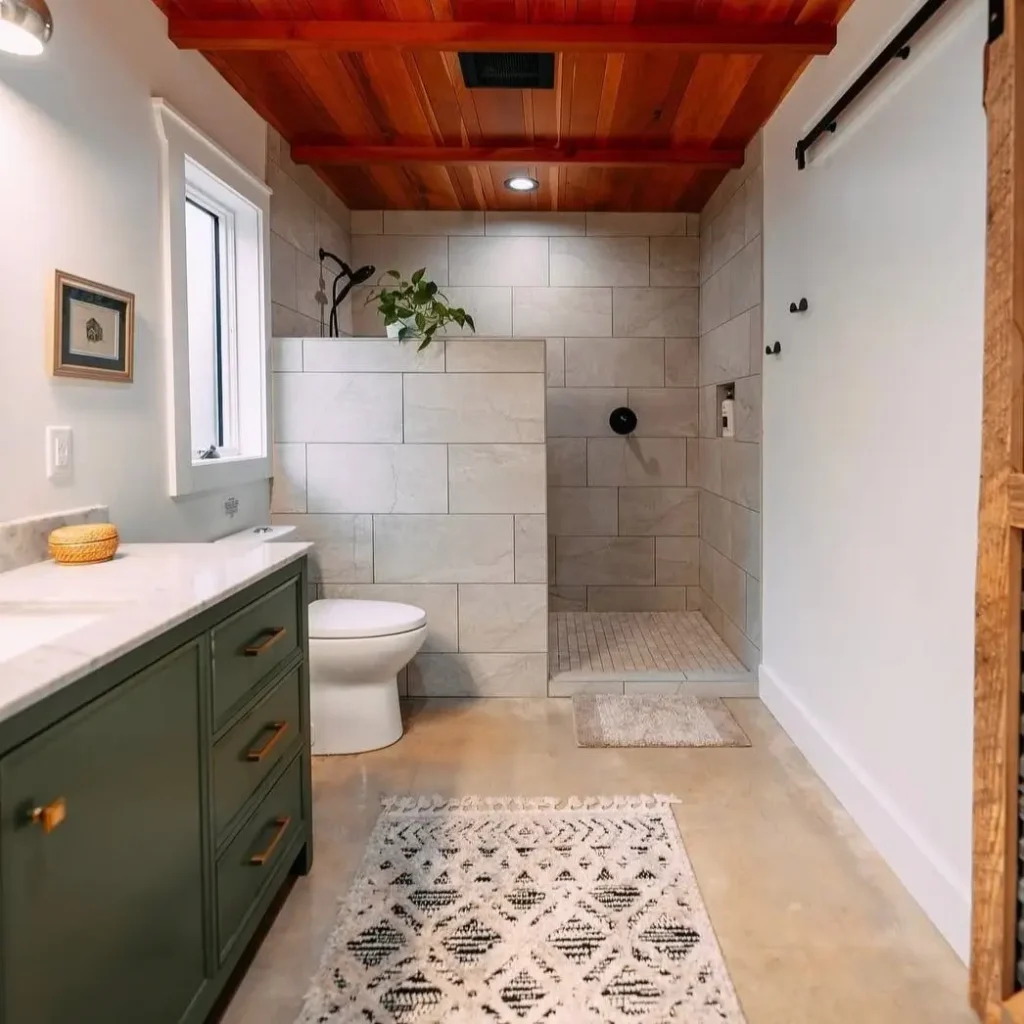 A modern rustic bathroom with a sage green vanity and a walk-in tiled shower.