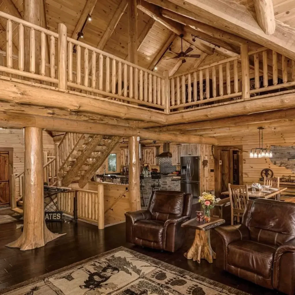 Spacious log cabin living room with high ceilings, leather chairs, and open layout.