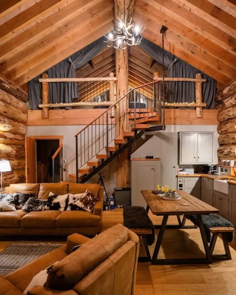 Spacious open-concept log cabin living and dining area with spiral staircase.