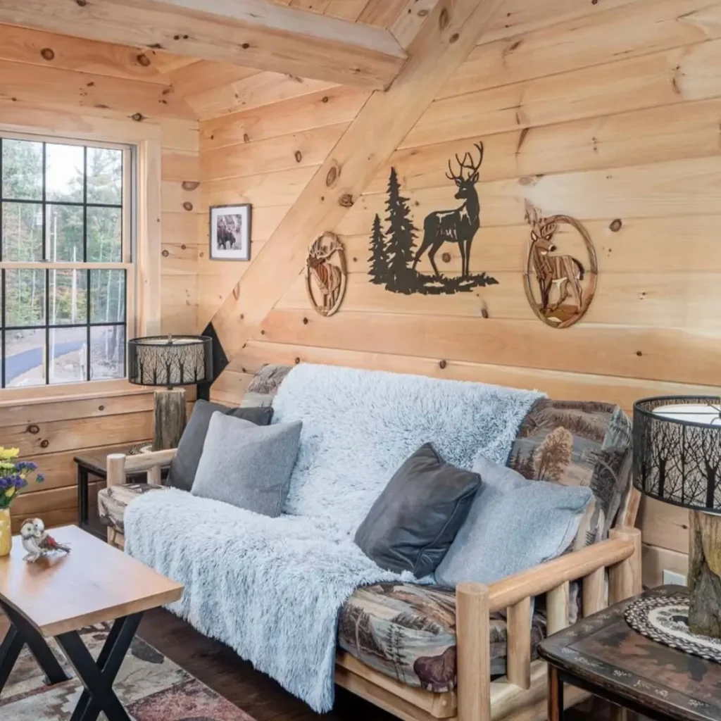 Cozy log cabin living room with wooden futon and deer motif wall art.