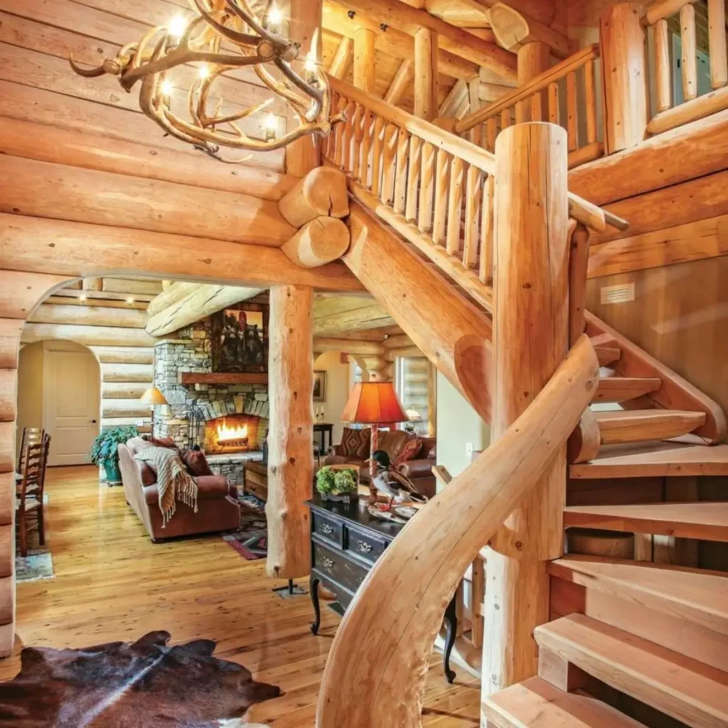 Grand log cabin interior with wooden staircase and antler chandelier.
