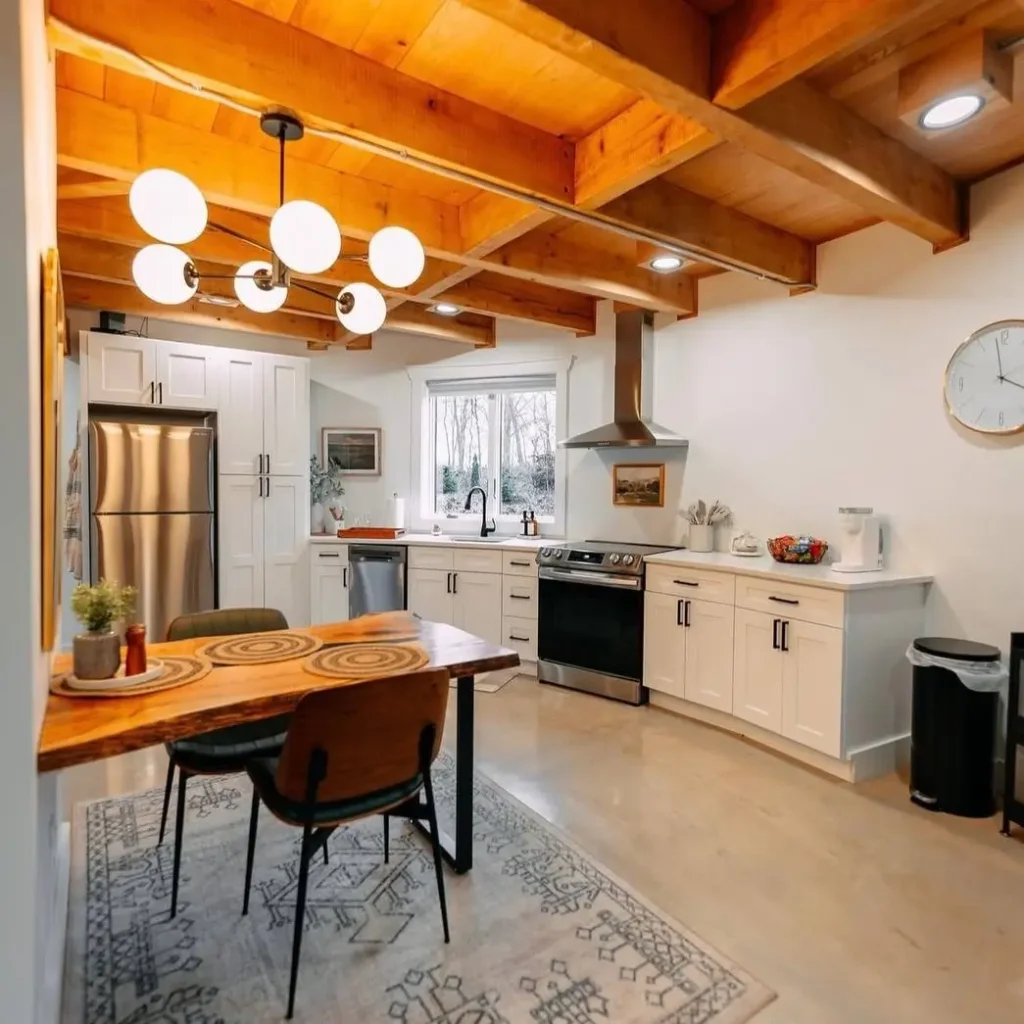 A modern kitchen within the grain silo home, featuring white shaker cabinets and a wood-topped dining peninsula.