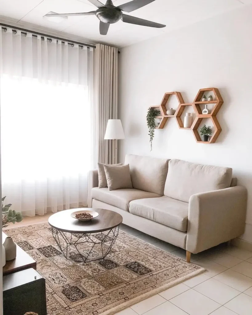 A neutral-toned living room with wooden honeycomb shelves above the sofa, a creative small apartment design idea on a budget.