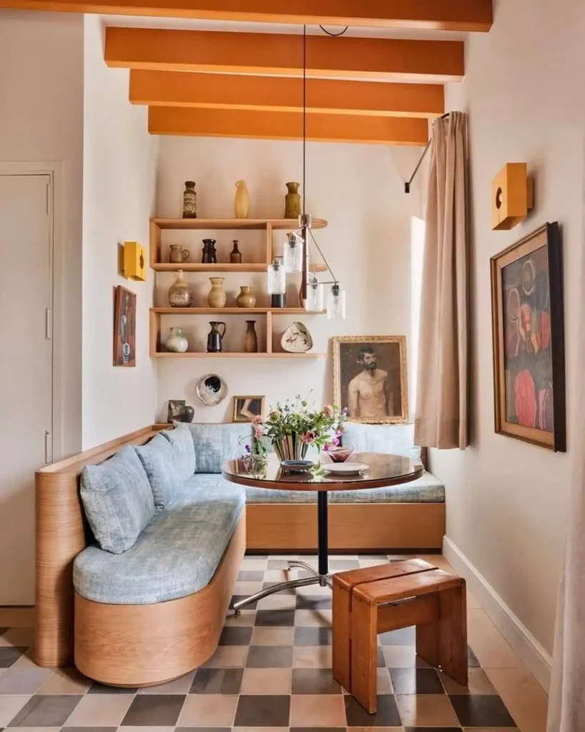 A cozy dining nook with custom banquette seating, showing a smart small apartment design idea on a budget.