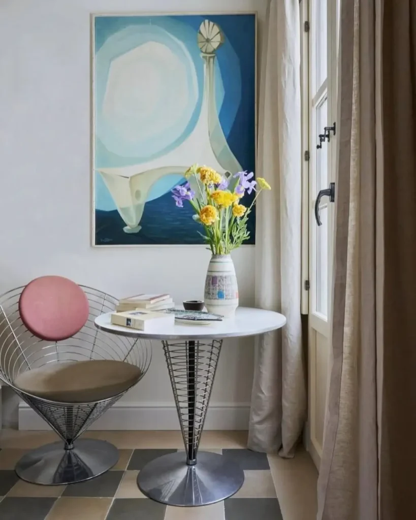 A small bistro table and wire chair creating a dining nook, an elegant small apartment decorating idea on a budget.