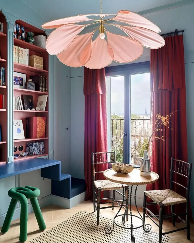 A colorful room featuring a large, pink flower-shaped pendant light, a bold small apartment design idea on a budget.
