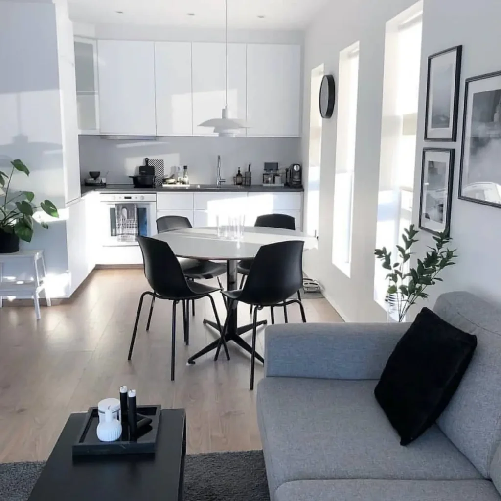 A minimalist open-plan apartment with black and white decor, a simple small apartment decorating idea.