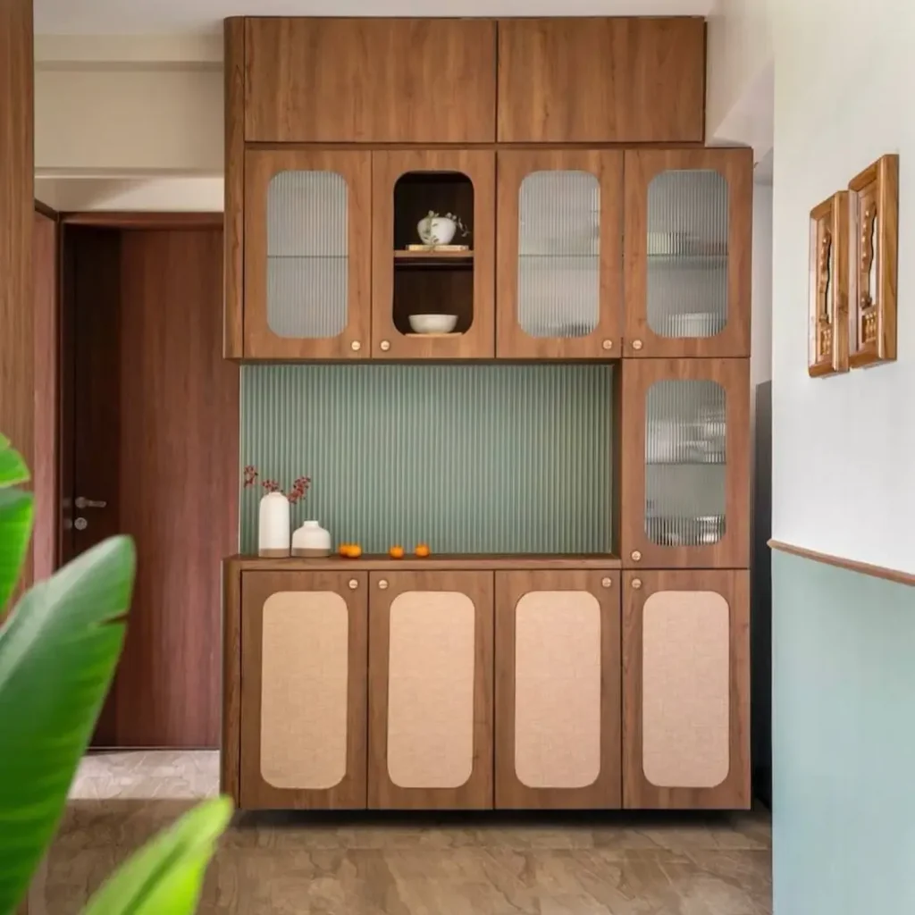 A tall wooden storage cabinet with fluted glass and rattan doors, a smart small apartment decorating idea on a budget.