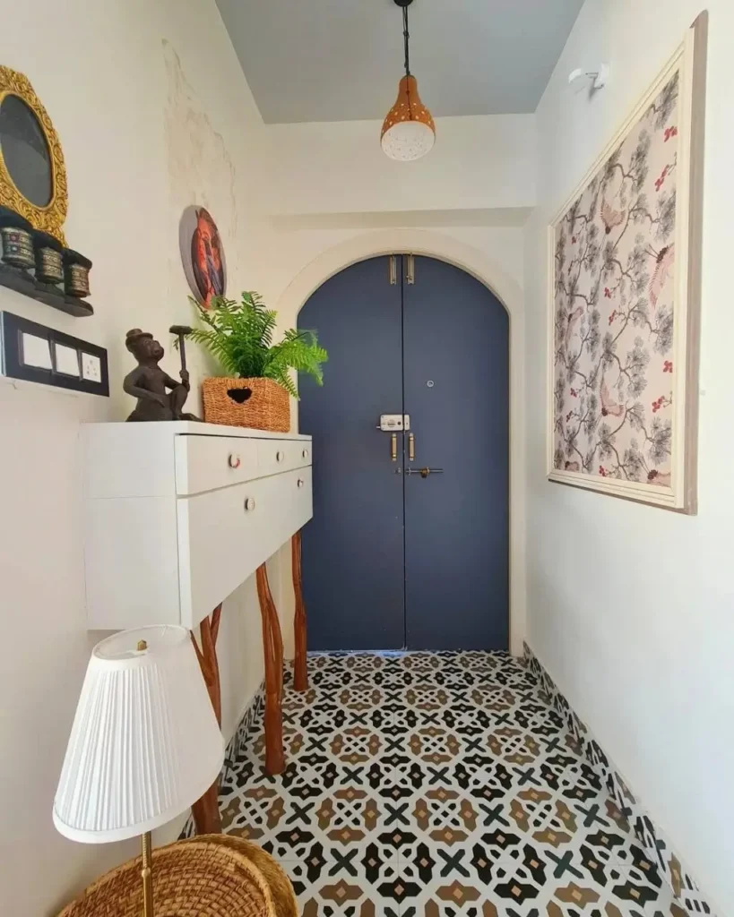 An entryway featuring bold, black-and-white patterned floor tiles, an effective small apartment design idea on a budget.