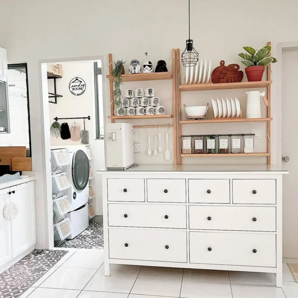 A white dresser repurposed as a kitchen coffee bar with open shelving above, showcasing a simple small apartment decorating idea.